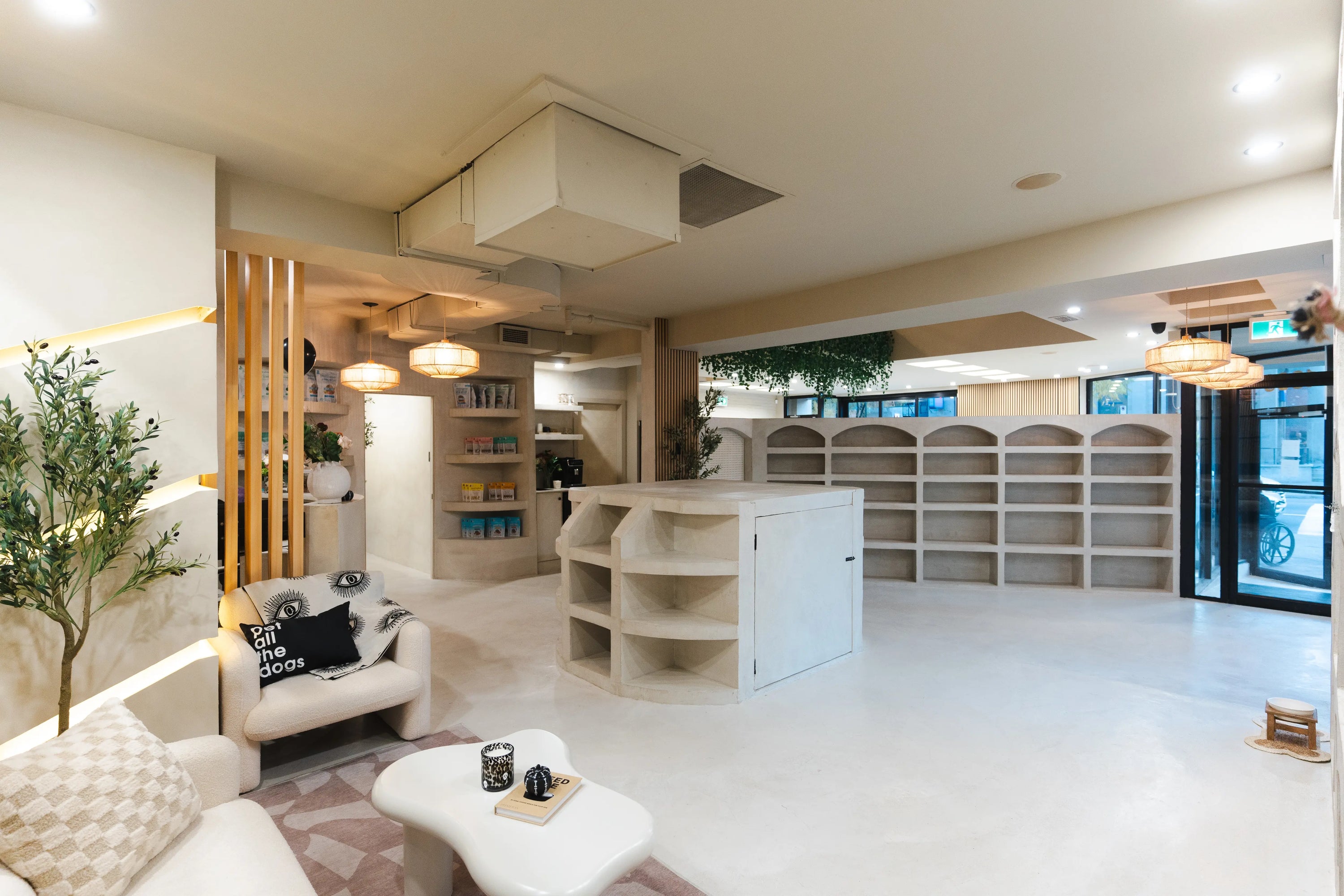 Modern dog daycare interior in Montreal featuring boutique-inspired design, pet retail shelves, and a cozy client lounge